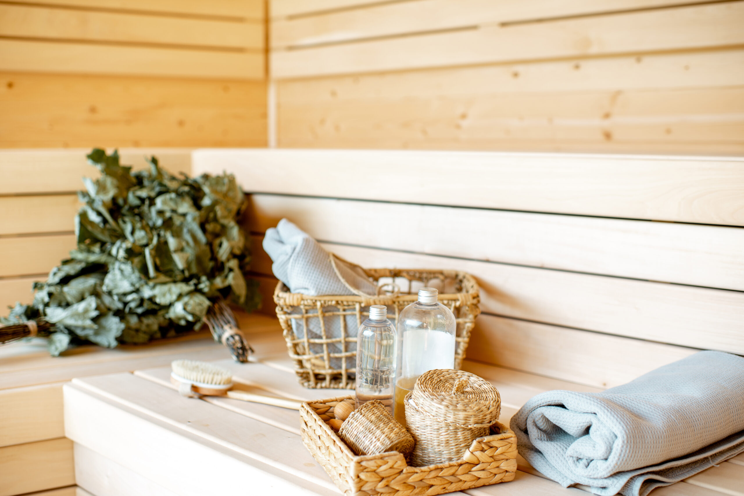 Accessories for resting in the sauna. Broom, towes, brush and some cosmetics on the wooden bench